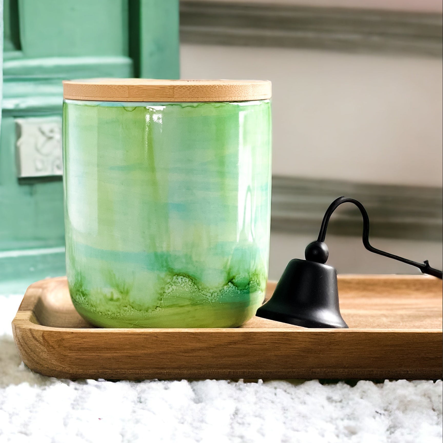 Tall, two wick ceramic soy candle handpainted in layers of greens and a hint of teal on a tray