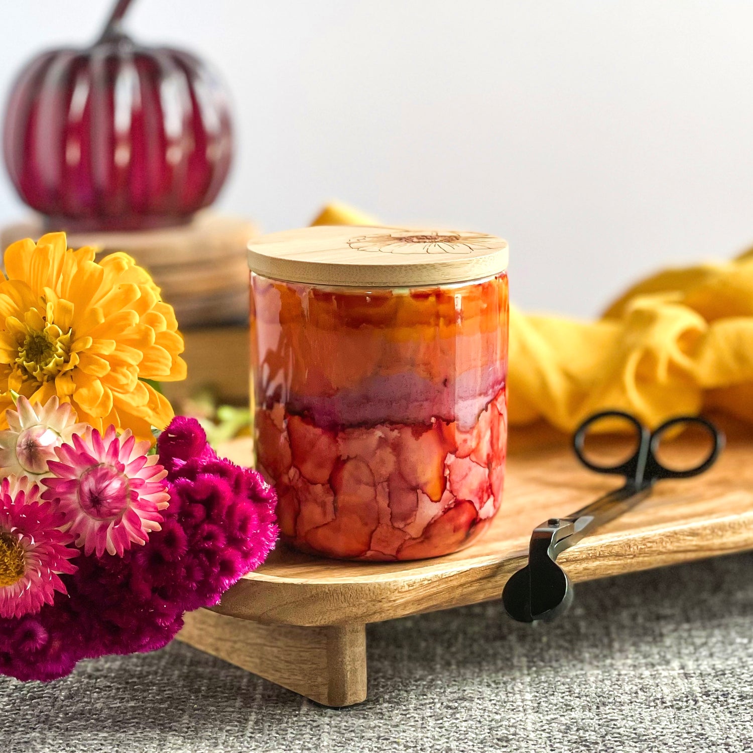 Vivid pinks, purples, and oranges surround this handpainted ceramic candle, unique candles for fall