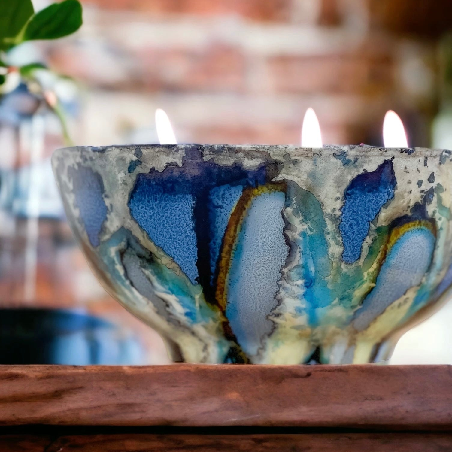 Handpainted, three wick ceramic candle in dramatic blues and grays with pops of yellow