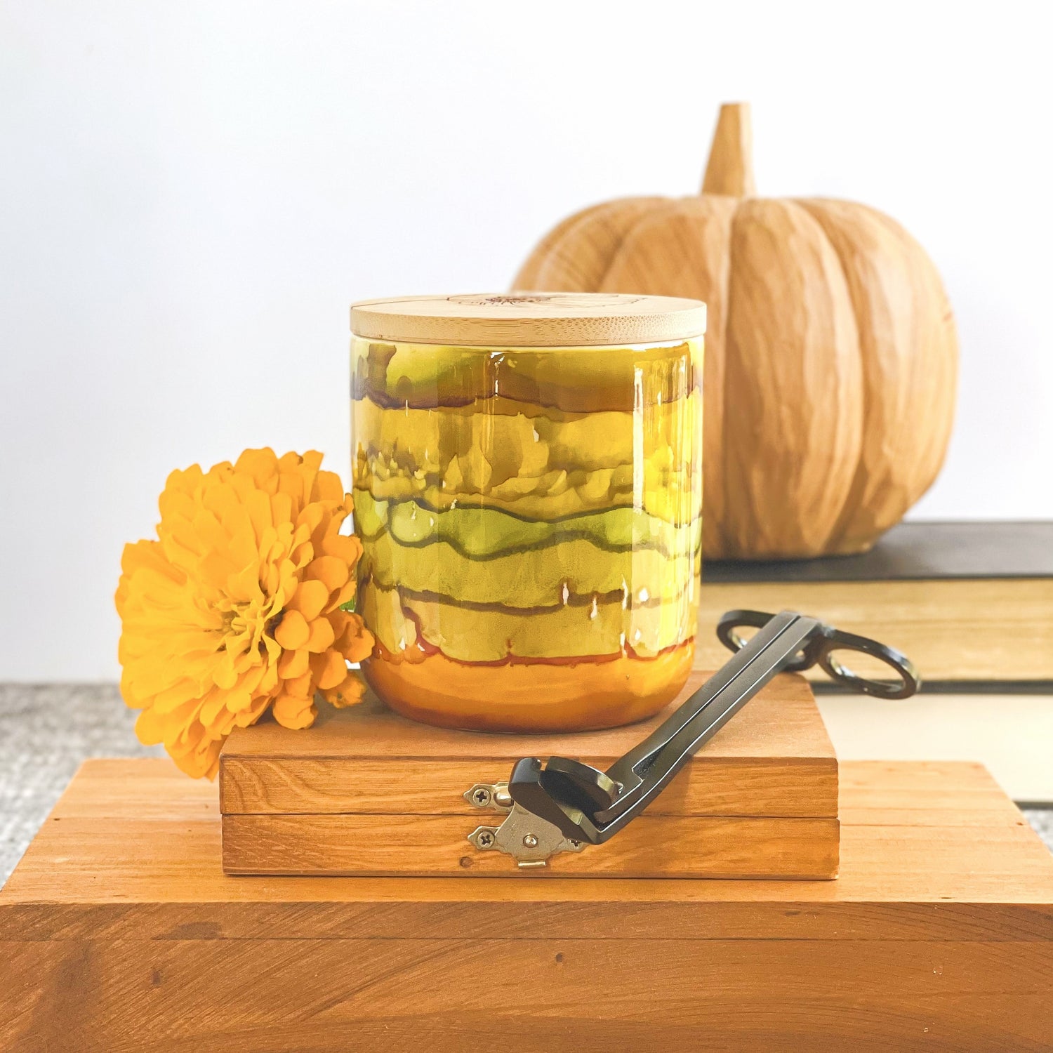 Handpainted ceramic candle in stacked shades of muted greens, golds, and amber, unique candles for fall