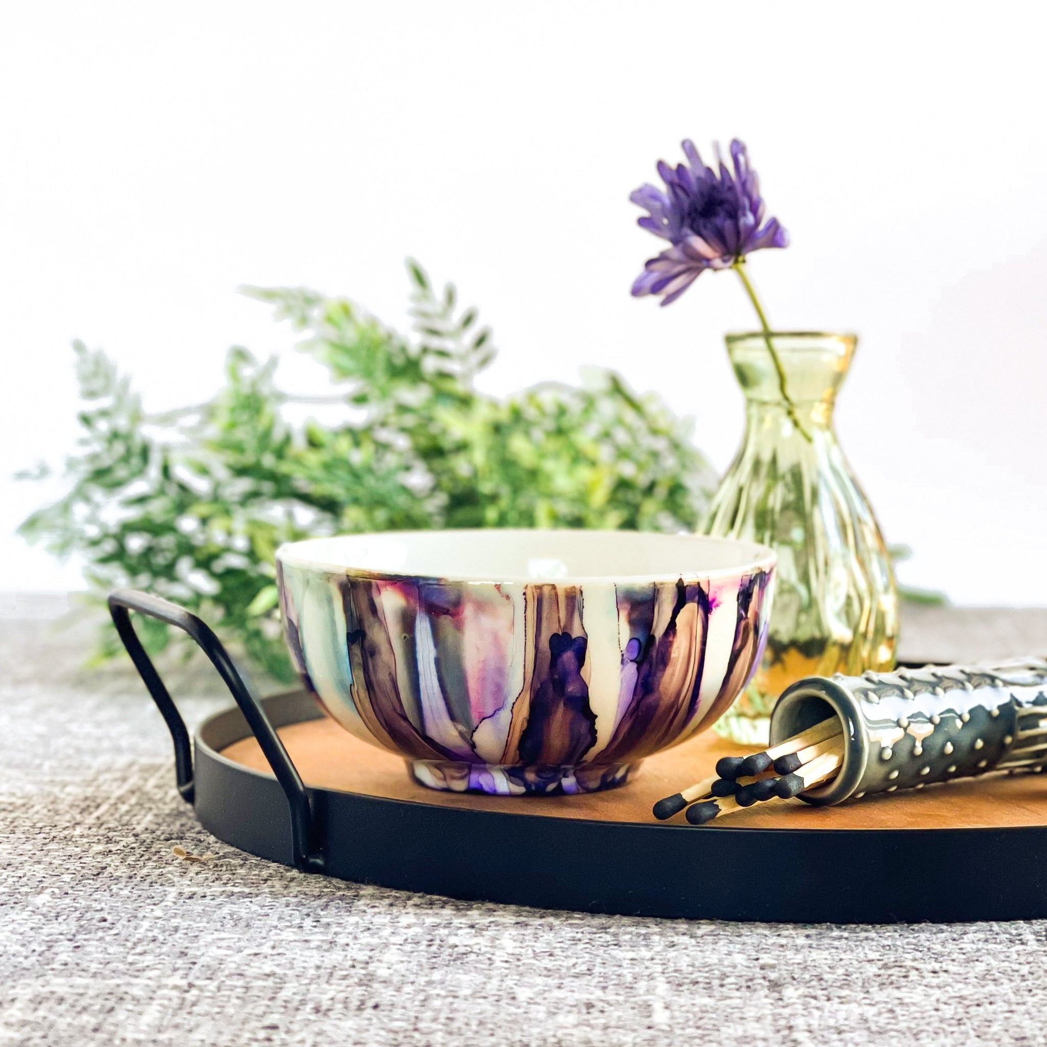 Ceramic three wick soy candle and painted in purples, grays and blacks