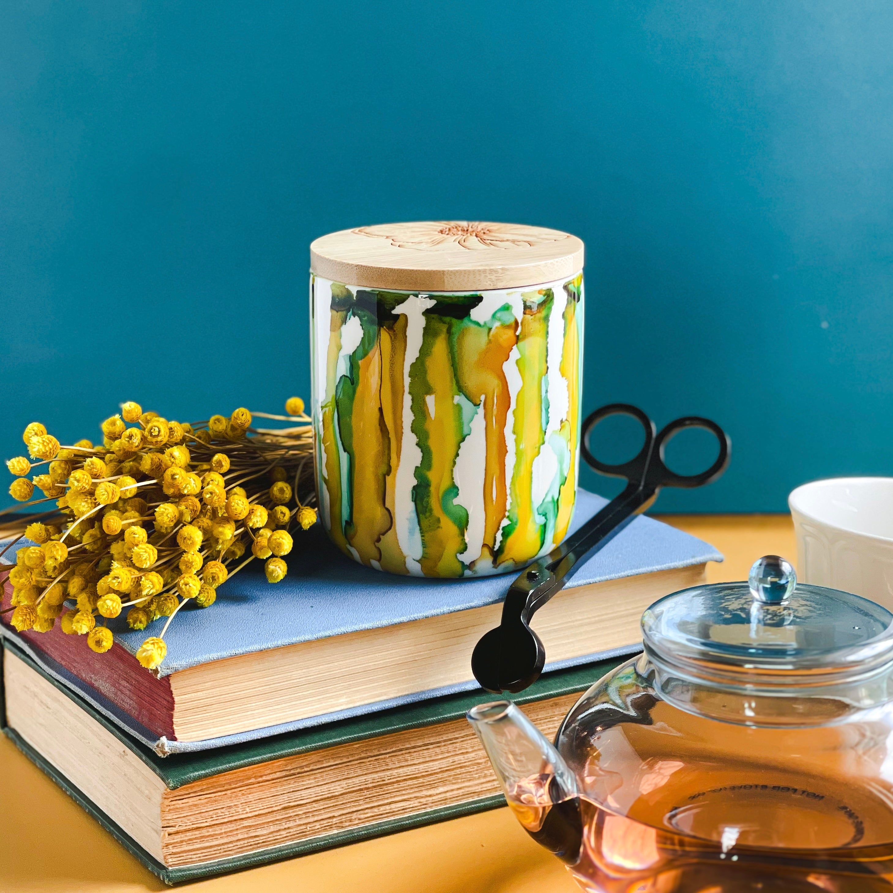 Tall, two wick ceramic candle handpainted in drippy soft teals and deep yellows