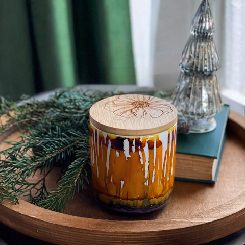 Hand painted ceramic candle in burnt oranges and purples 