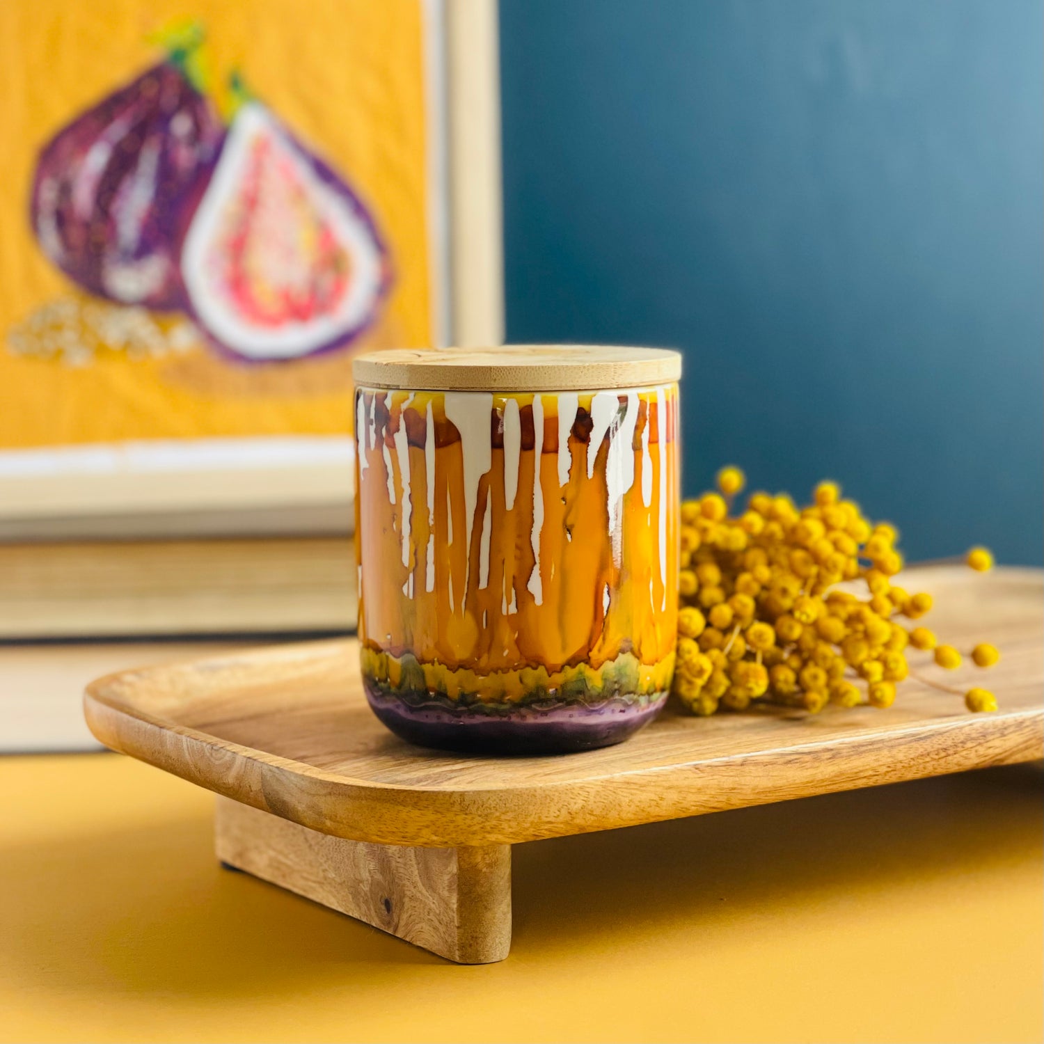 Tall, two wick ceramic candle handpainted in drippy oranges, warm yellows, and dusky purple
