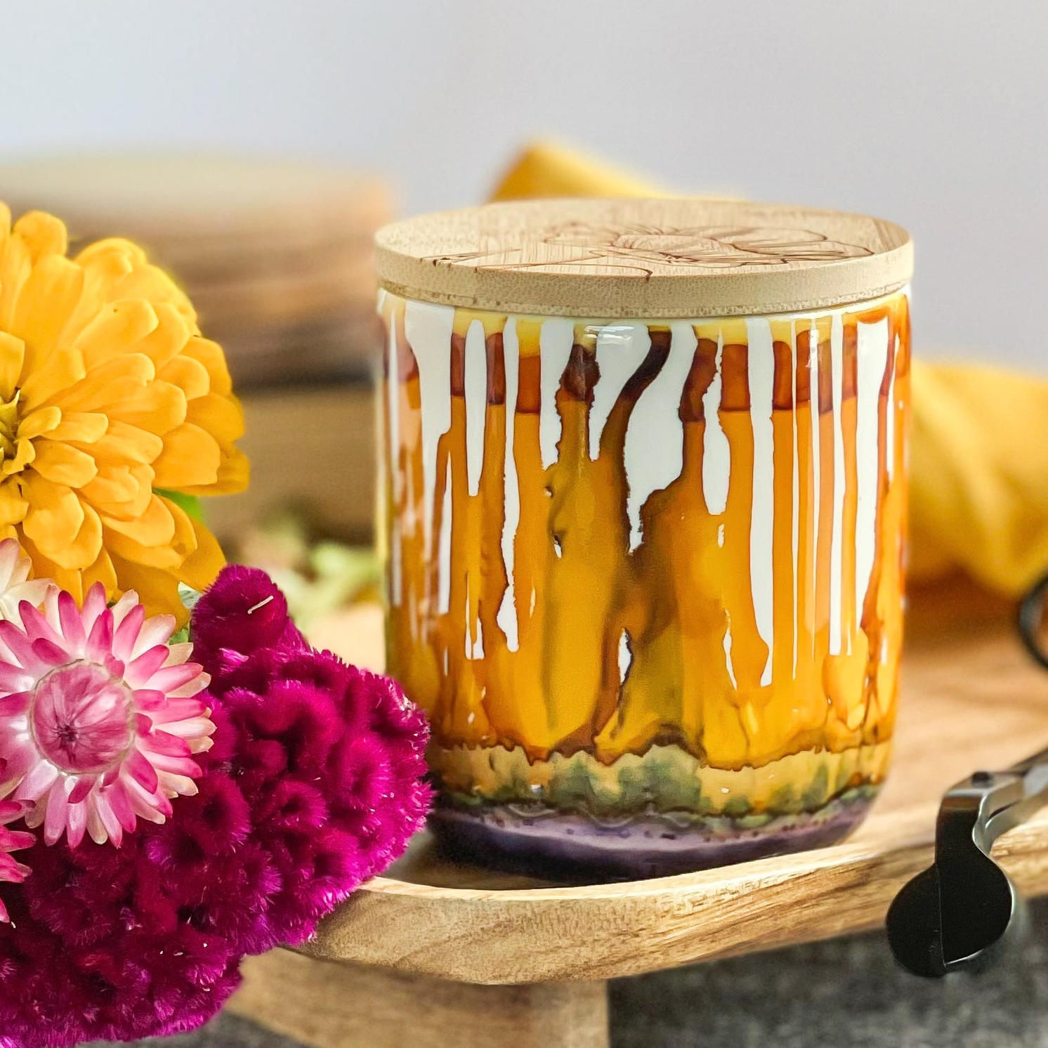 Tall, two wick ceramic candle handpainted in drippy oranges, warm yellows, and dusky purple