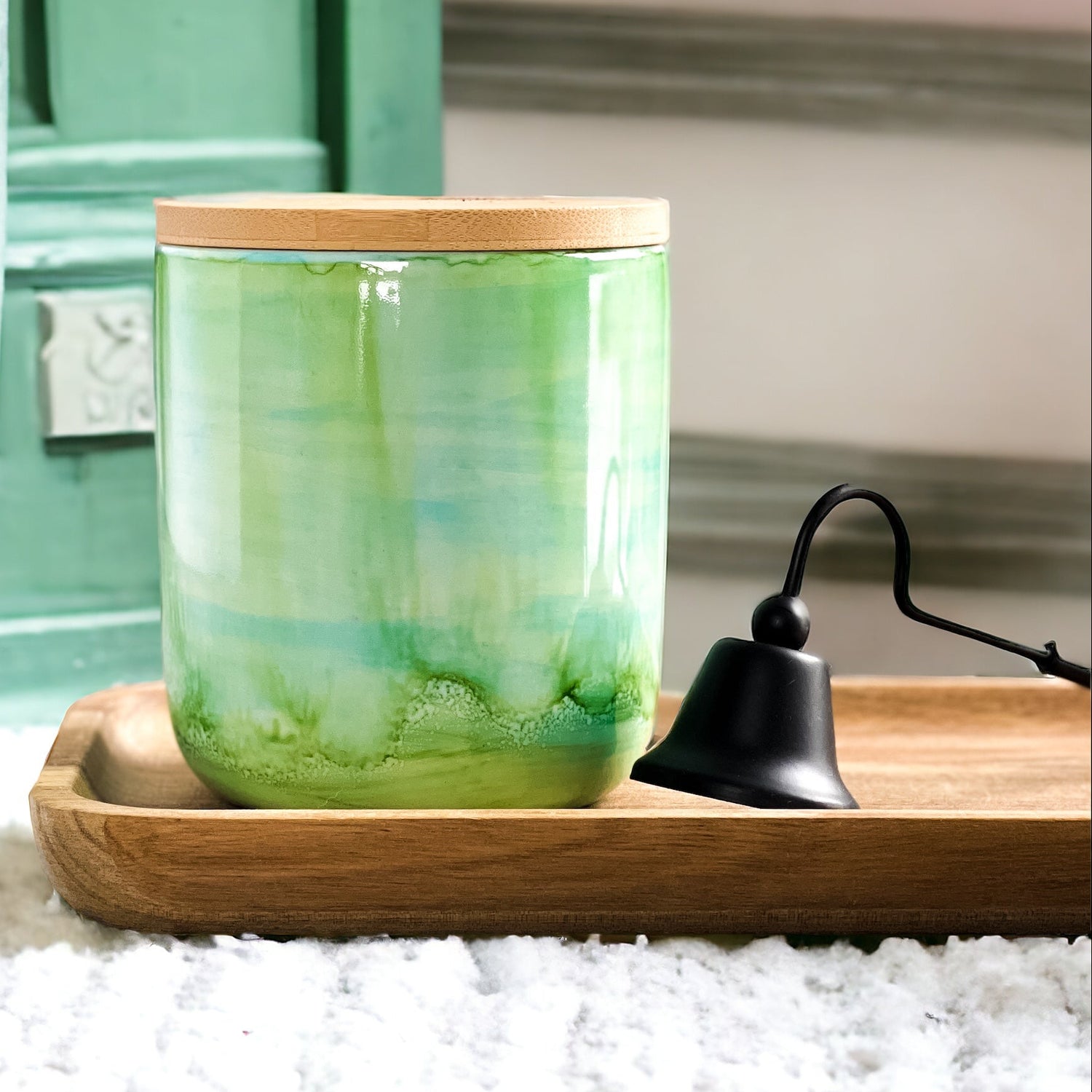 Tall, two wick ceramic soy candle handpainted in layers of greens and a hint of teal on a tray