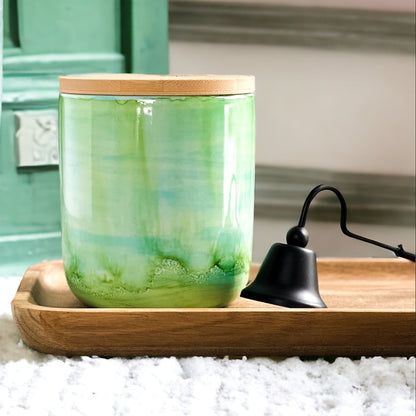 Tall, two wick ceramic soy candle handpainted in layers of greens and a hint of teal on a tray