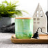 Tall, two wick ceramic soy candle handpainted in layers of greens and a hint of teal