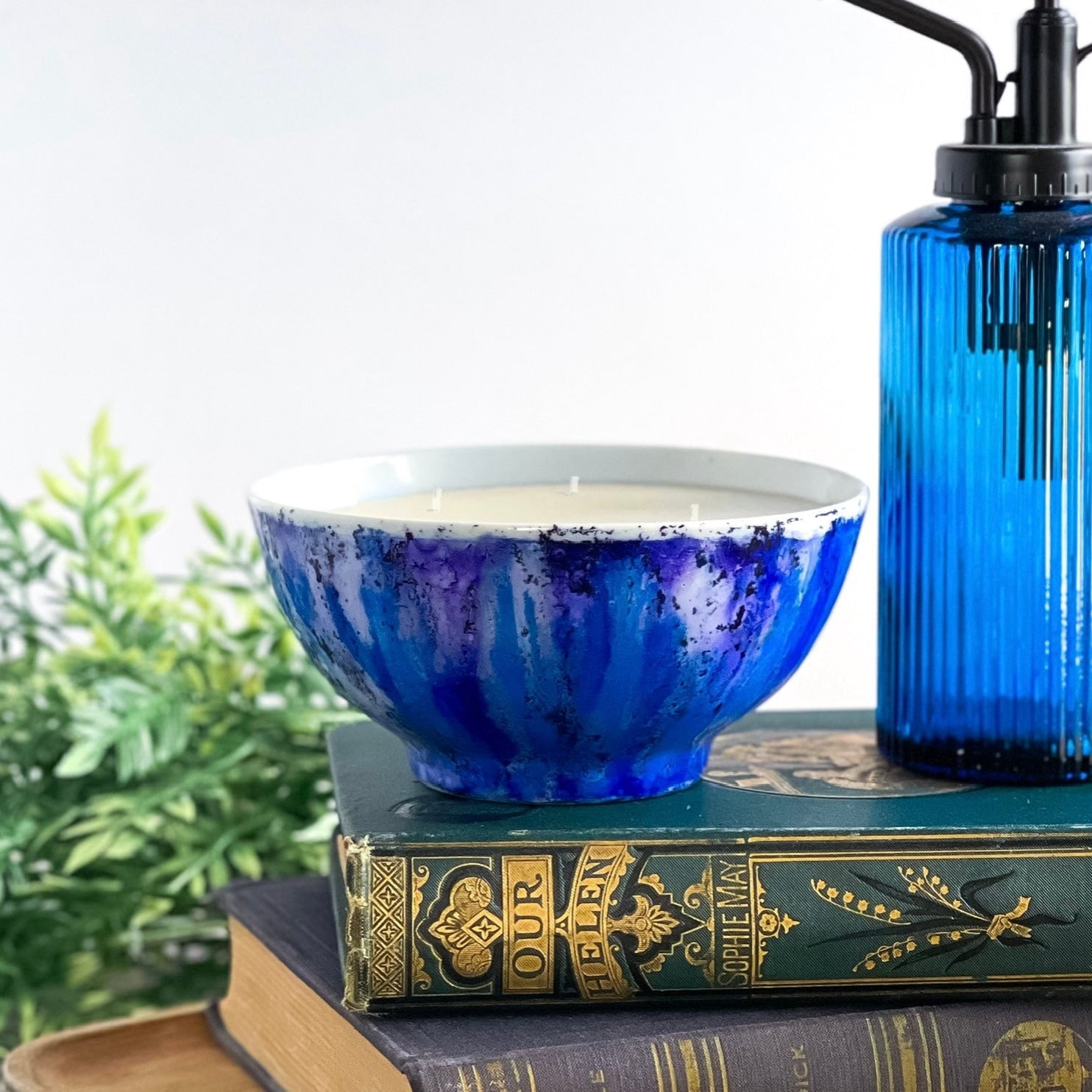 Handpainted, three wick ceramic candle in bold blues and a touch of purple