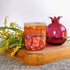 Tall, two wick ceramic soy candle handpainted in shades of red, raspberry, deep orange, and a touch of purple