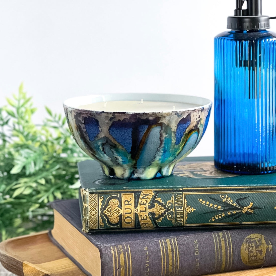 Handpainted, three wick ceramic candle in dramatic blues and grays with pops of yellow