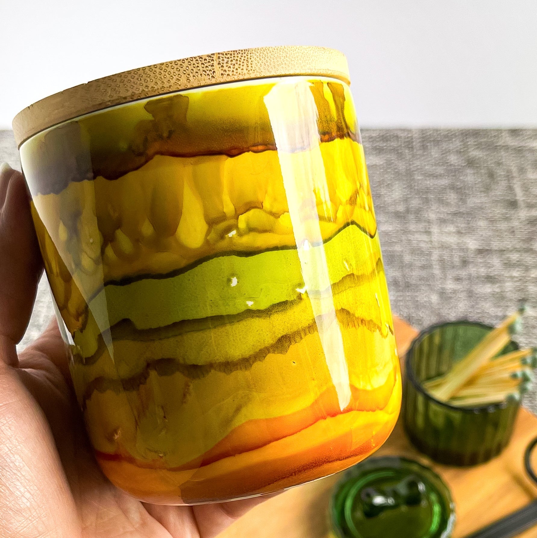 Tall, two wick ceramic candle handpainted in shades of green, gold, honey, and amber