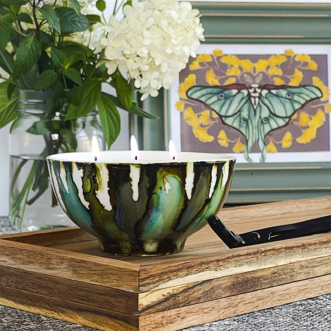Handpainted, three wick ceramic candle in muted layers of green, blue and dark brown