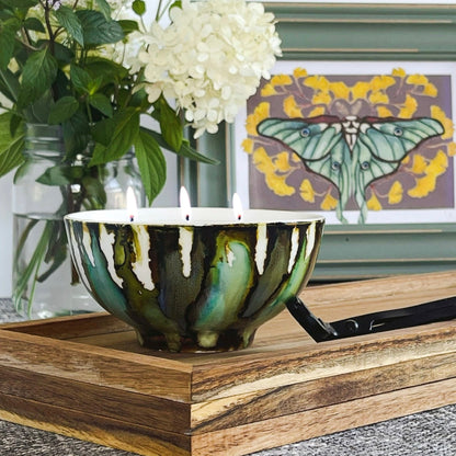 Handpainted, three wick ceramic candle in muted layers of green, blue and dark brown