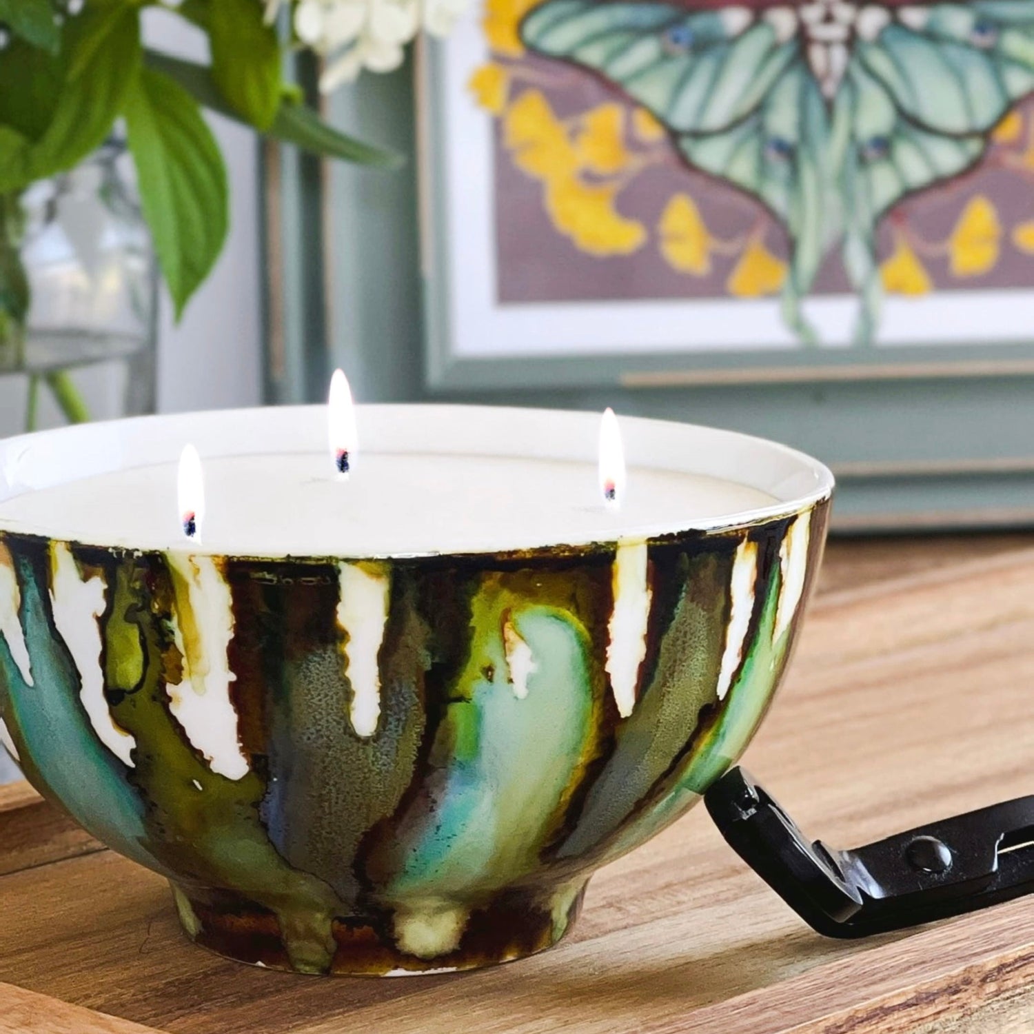 Handpainted, three wick ceramic candle in muted layers of green, blue and dark brown