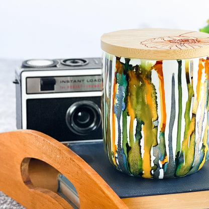 Tall, two wick ceramic soy candle handpainted in blues, greens, yellows and shimmery gold