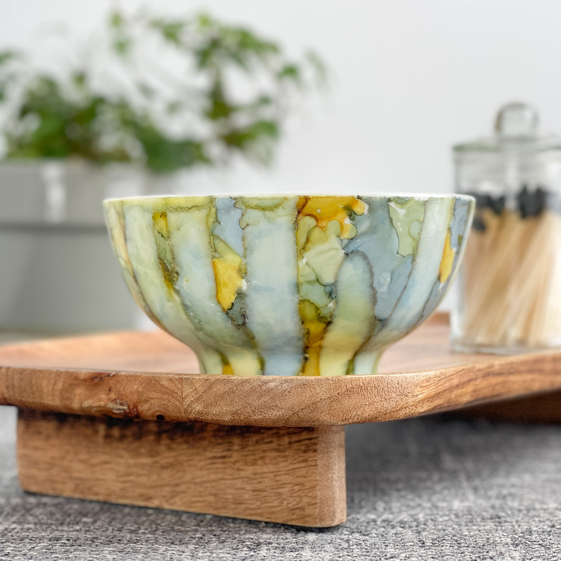 Handpainted ceramic candle in soft shades of blue, yellow and green