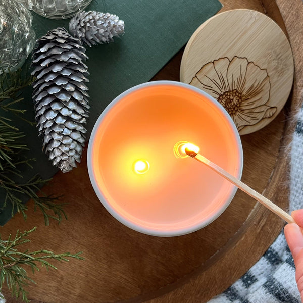 Tope view of a handpainted ceramic candle being lit