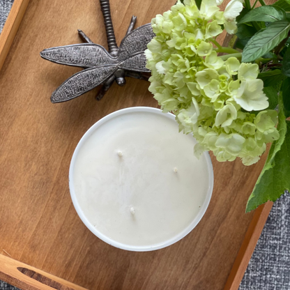 Top view of an unlit three wick candle on a tray with flowers