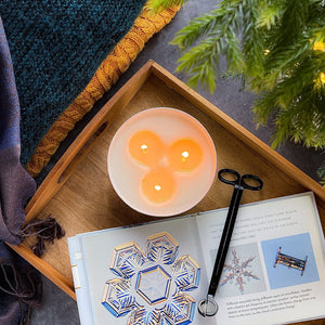 top view of a three wick winter candle burning