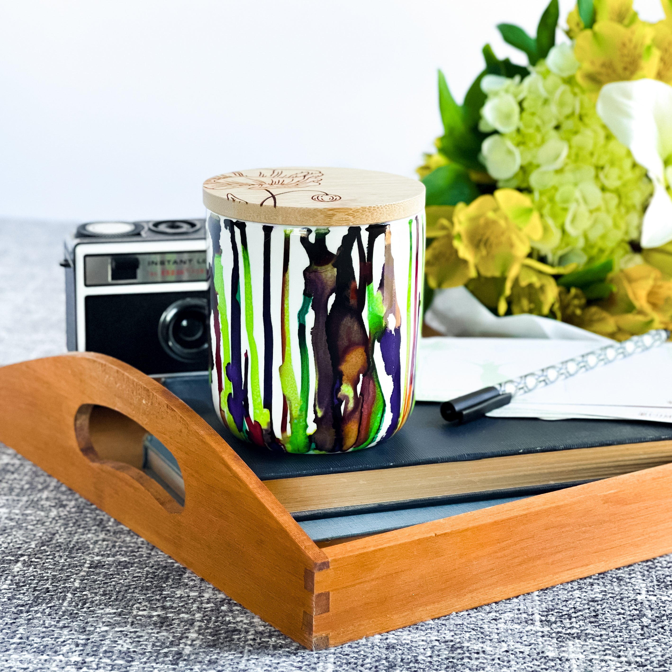 Tall, two wick ceramic soy candle handpainted in bright greens and deep purples
