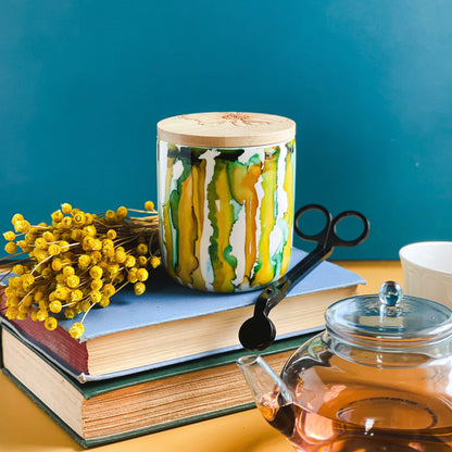 Tall, two wick ceramic candle handpainted in drippy soft teals and deep yellows