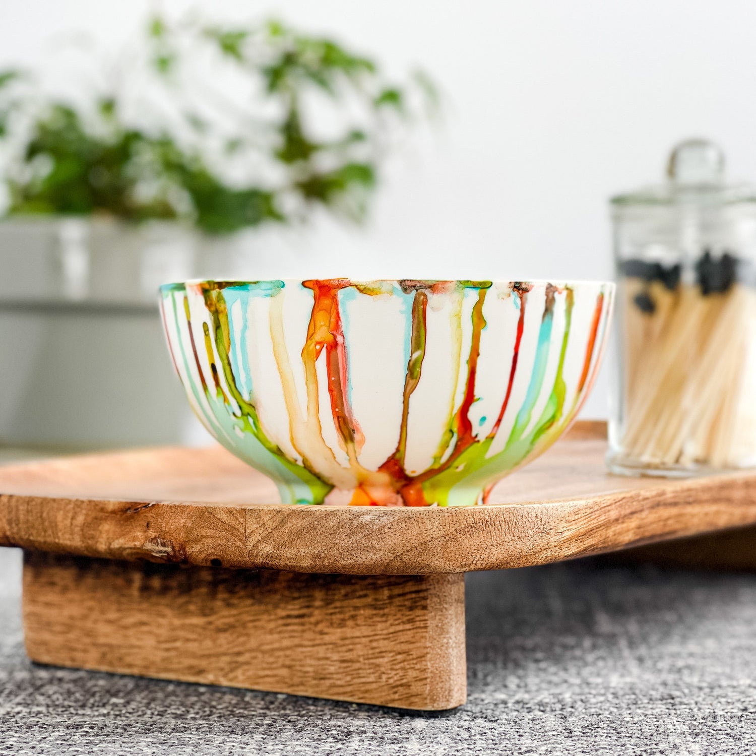 Colorful handpainted ceramic candle in shades of red, green, teal and yellow