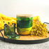 Tall, two wick ceramic candle handpainted in bands of mossy and forest greens with a base of warm yellow