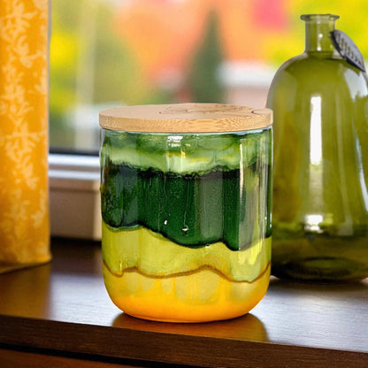 Tall, two wick ceramic candle handpainted in bands of mossy and forest greens with a base of warm yellow